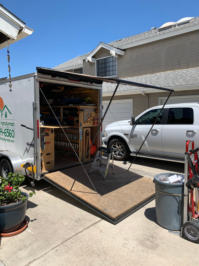 Cargo trailer with ramp door and attached retractable awning